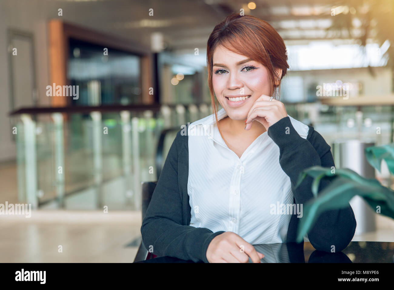 Asian Business Office Frauen schauen und lächeln in modernes Gebäude Hintergrund Stockfoto