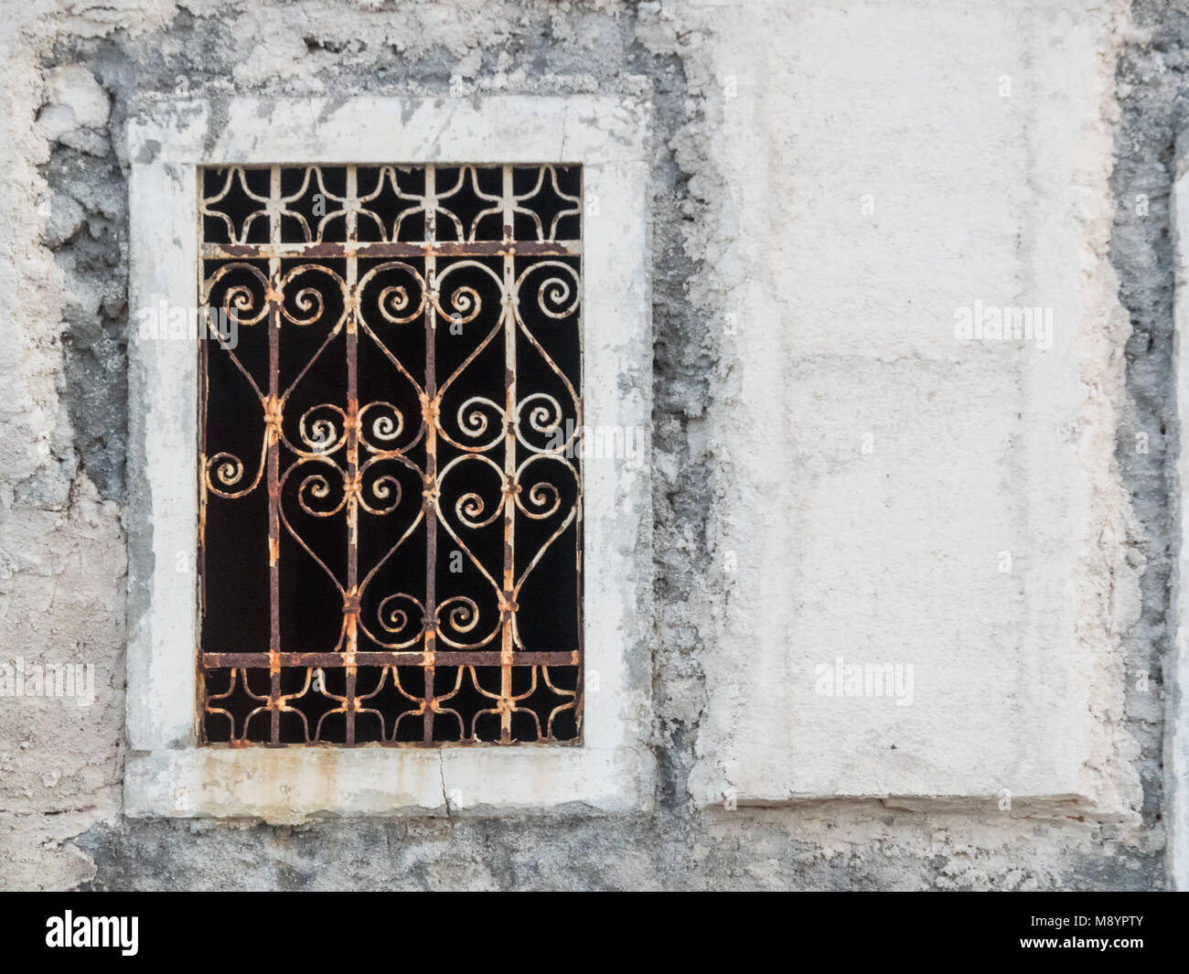 Fenster mit verziert Eisenstangen in einem weißen Gebäude in Kroatien Stockfoto