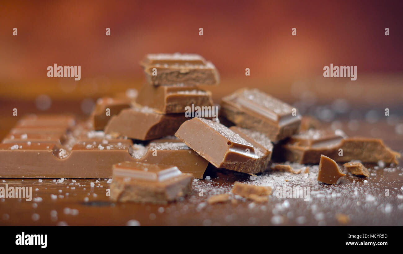 Süß und salzig Schokolade Snacks, gesalzen Karamell Bar, Makro Nahaufnahme auf rustikalem Holz Hintergrund. Stockfoto