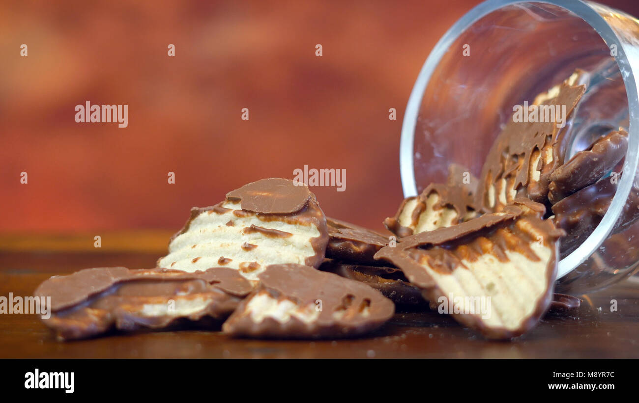 Süße und salzige Snacks, schokolade Salz und Essig Kartoffelchips, Makro Nahaufnahme auf rustikalem Holz Hintergrund mit kopieren. Stockfoto