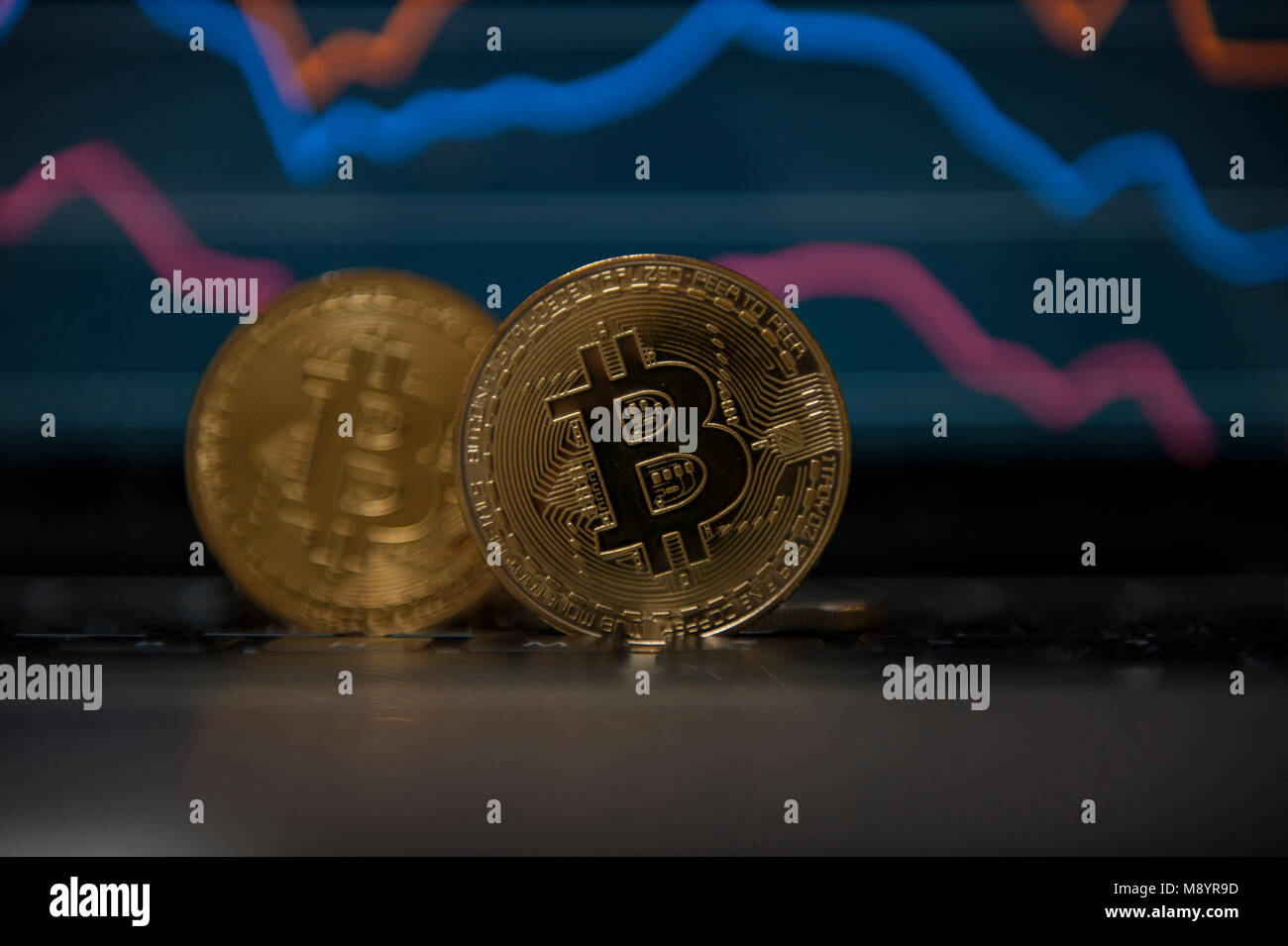 2 Bitcoin cryptocurrency Münzen gesehen infront Börse Grafiken Stockfoto