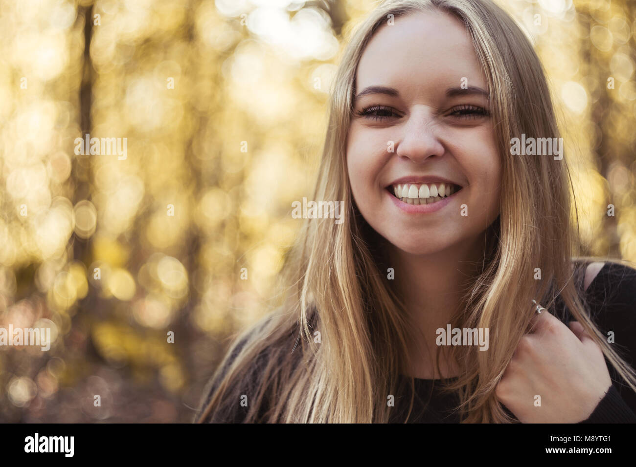 Portrait eines glücklichen jungen Frau mit breitem Lächeln und lange blonde Haare Stockfoto