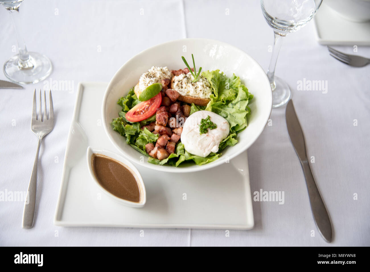 Schönen Ziegenkäse und Bean grüner Salat auf weißem Tischtuch und weißes Porzellan serviert. Hohe Qualität Restaurant Foto. Stockfoto
