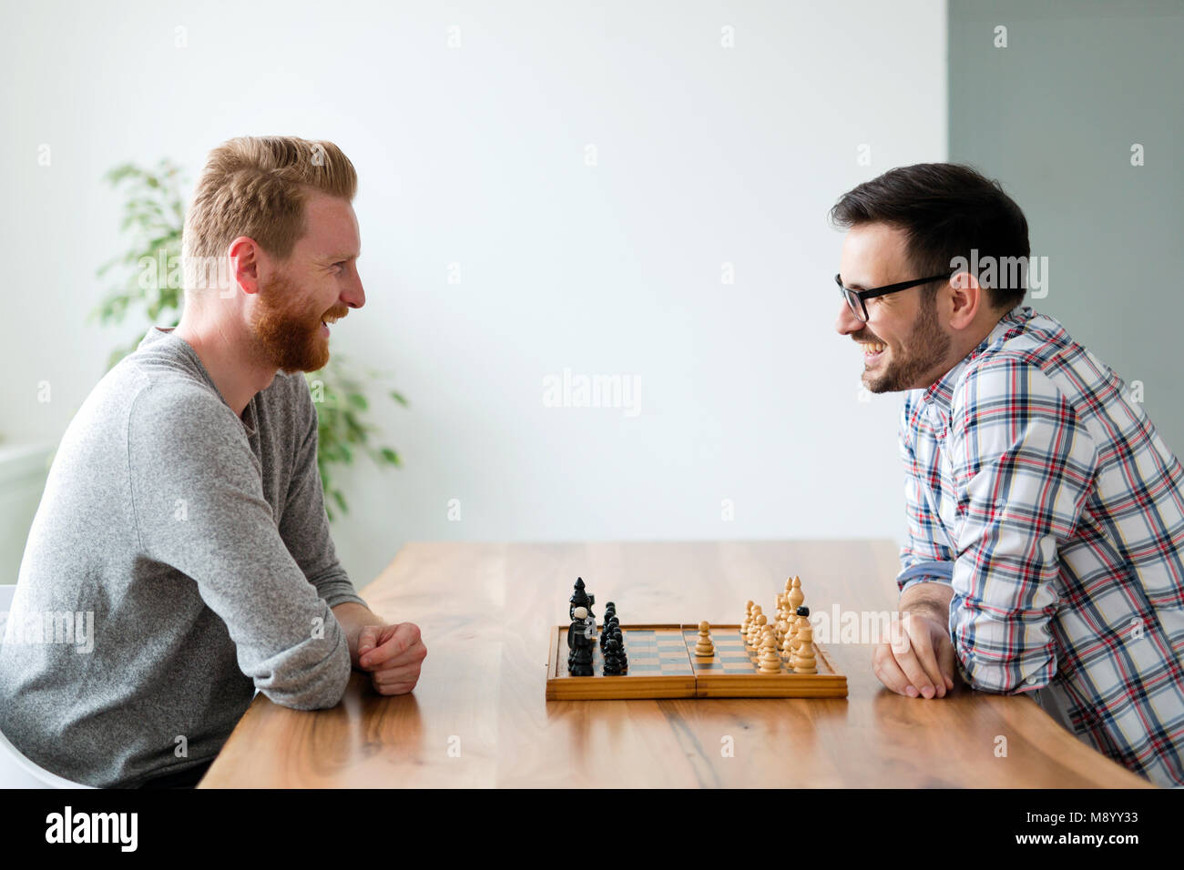 Porträt von zwei jungen Mann spielen Schach Stockfoto