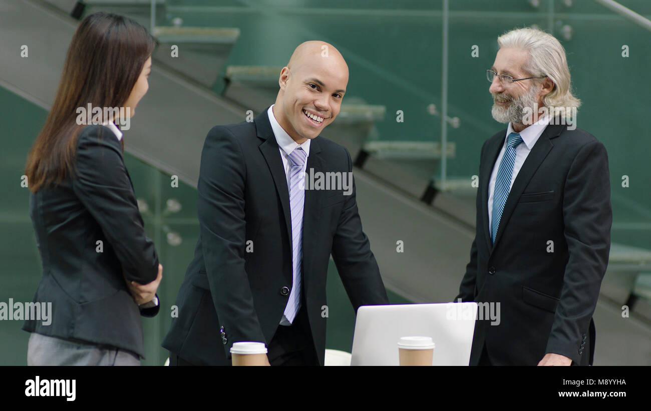Erfolgreiche junge Corporate Executive von Boss auf Kamera gelobt und lächelnd. Stockfoto