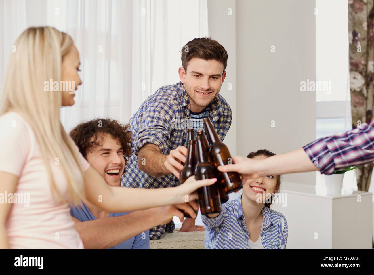 Eine Gruppe von Freunden sind, klirrenden Flaschen in einer Sitzung. Stockfoto