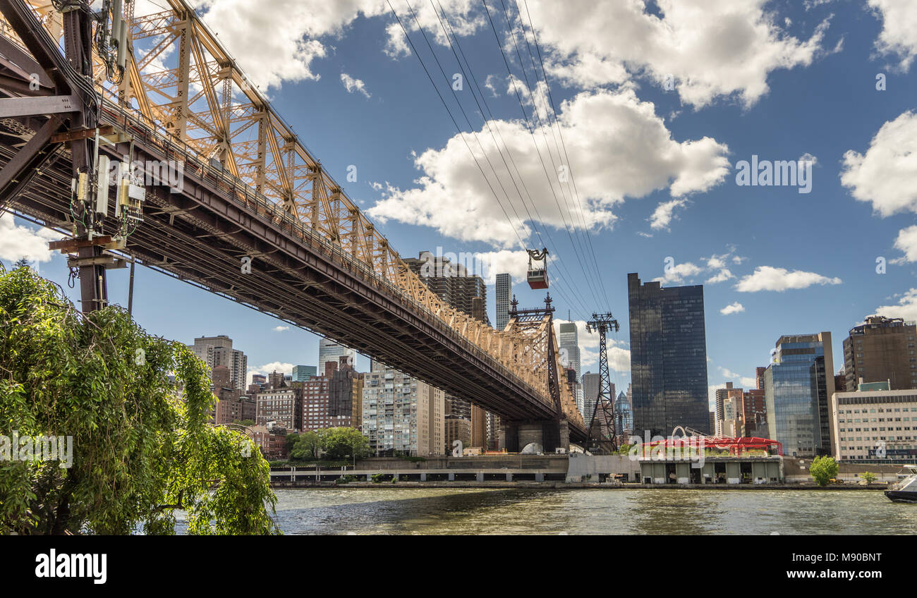 Blick von Roosevelt Island von 59th Street Bridge, Straßenbahn, Manhattan Skyline und den East River. Stockfoto