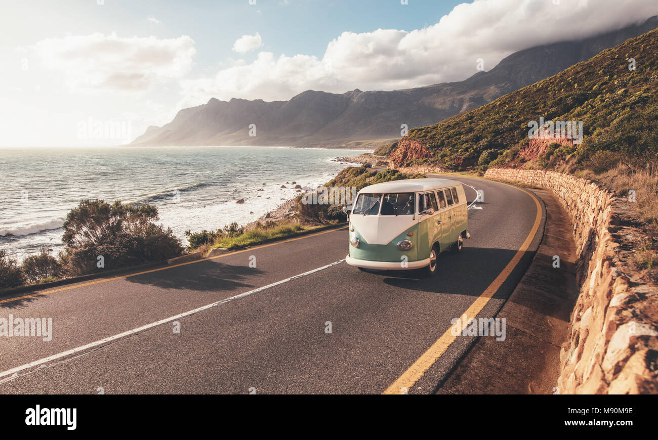 Mini Van auf der Küstenstraße. Gruppe von Freunden unterwegs von einem van auf der Autobahn entlang des Meeres. Stockfoto