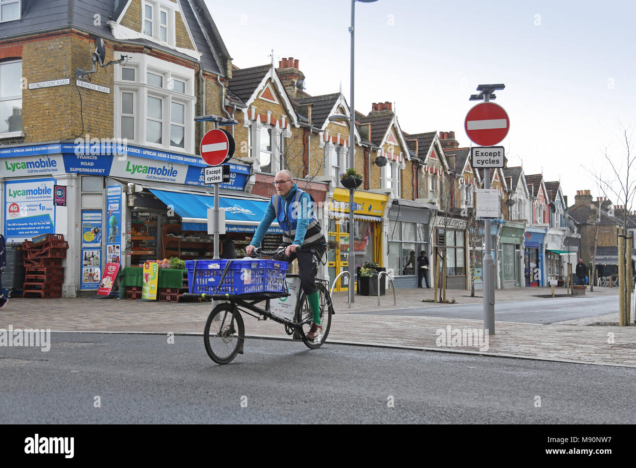 Ein Radfahrer auf einem cargo bike auf Francis Straße, Wathamstow, London. Eine neu Fußgängerzone und Einkaufsstraße. Teil des neuen Mini Holland Regelung Stockfoto