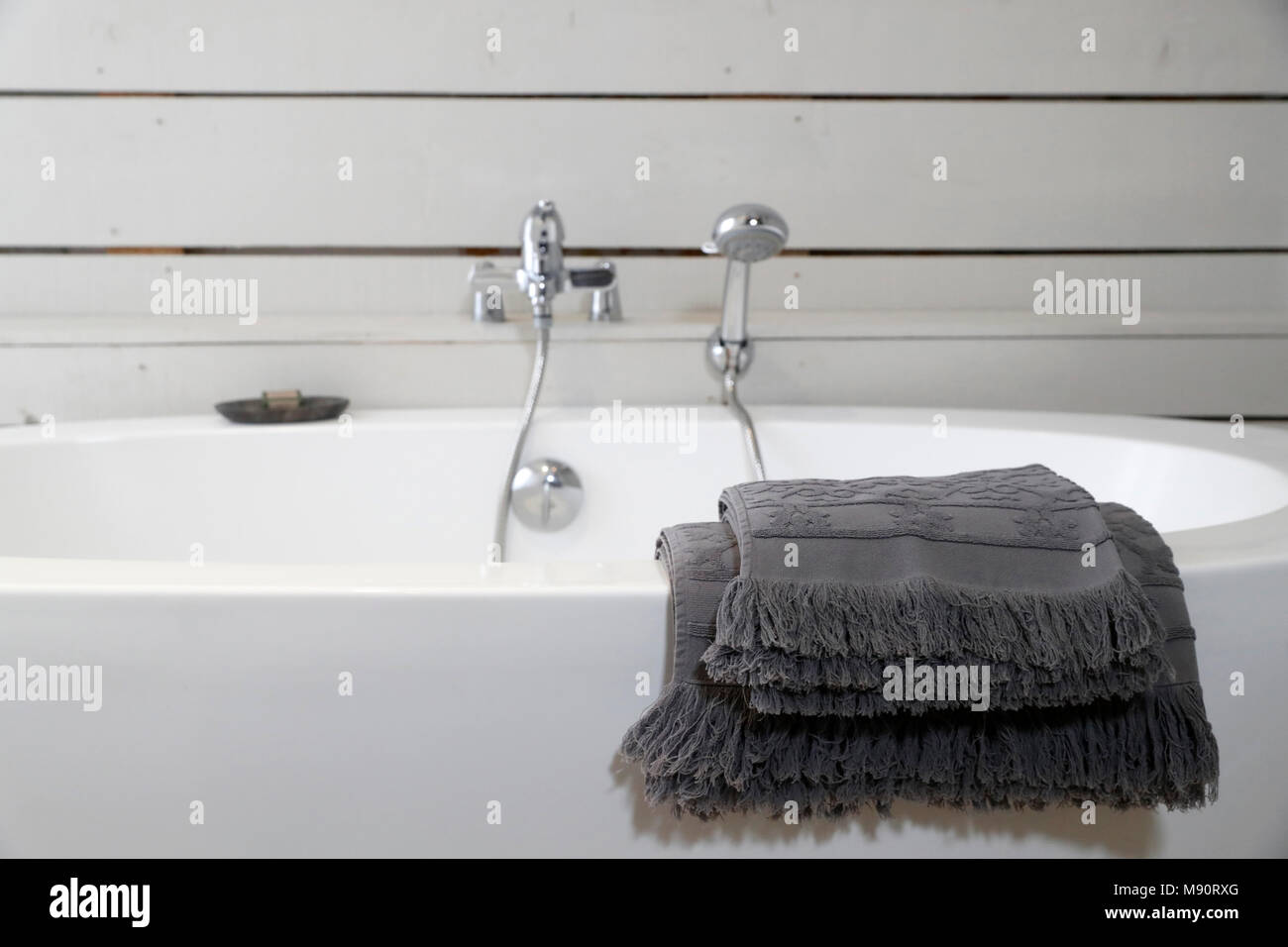 Moderne Keramikbadewanne mit Handtüchern. Stockfoto