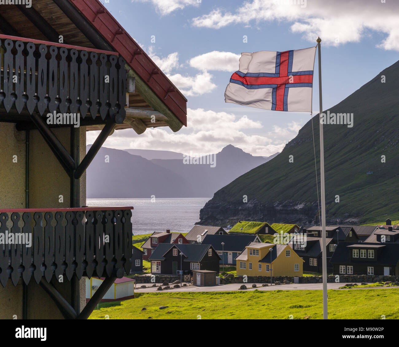 Flagge der Färöer in der Brise über dem Dorf Gjógv auf den Färöer, Dänemark fliegen. Sommer (Juni) 2017. Stockfoto