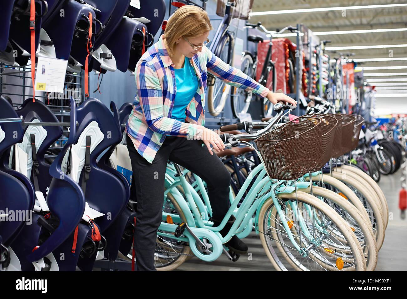 Frau entscheidet, Fahrrad im Sportgeschäft Stockfoto