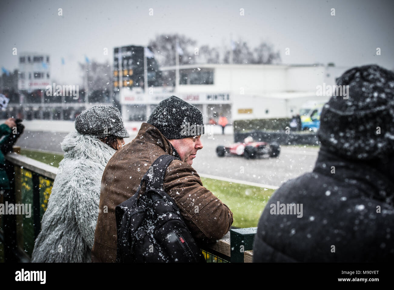Zuschauer einfrieren im Schnee beobachten die Formel 5000 Demonstration des Antriebs beim Goodwood Mitgliederversammlung 76 MM in Goodwood Motor Circuit Stockfoto