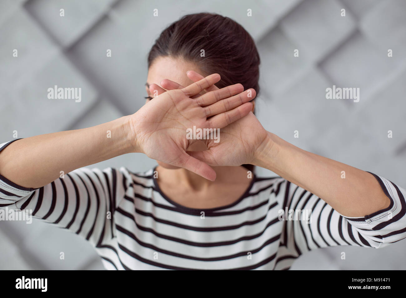 Schöne junge Frau, die ihr Gesicht Stockfoto