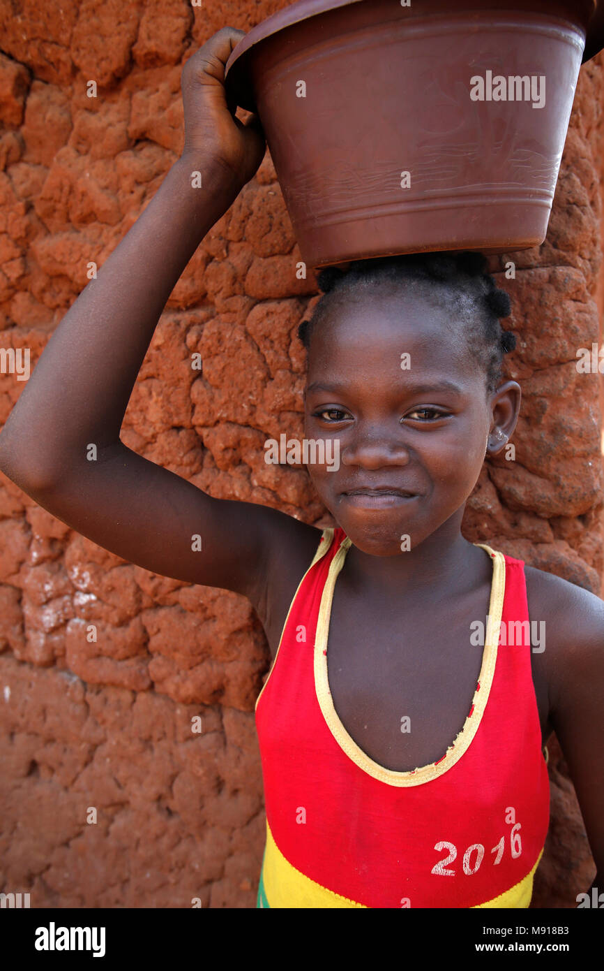 Mädchen, die einen Eimer auf dem Kopf in einem Zou Provinz Dorf, Benin. Stockfoto