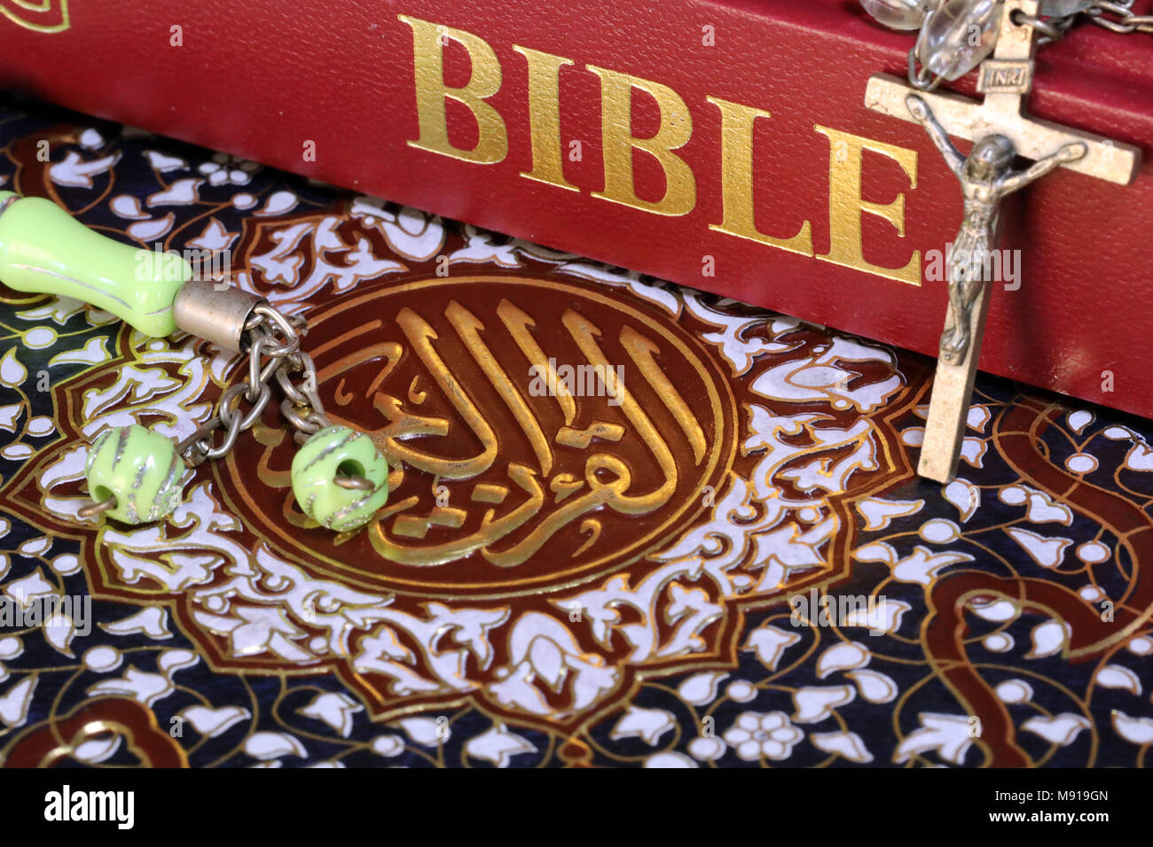 Christentum, Islam 2 monotheistischen Religionen. Bibel, Koran. Kruzifix und Gebet Perlen. Interreligiöse Symbole. Stockfoto
