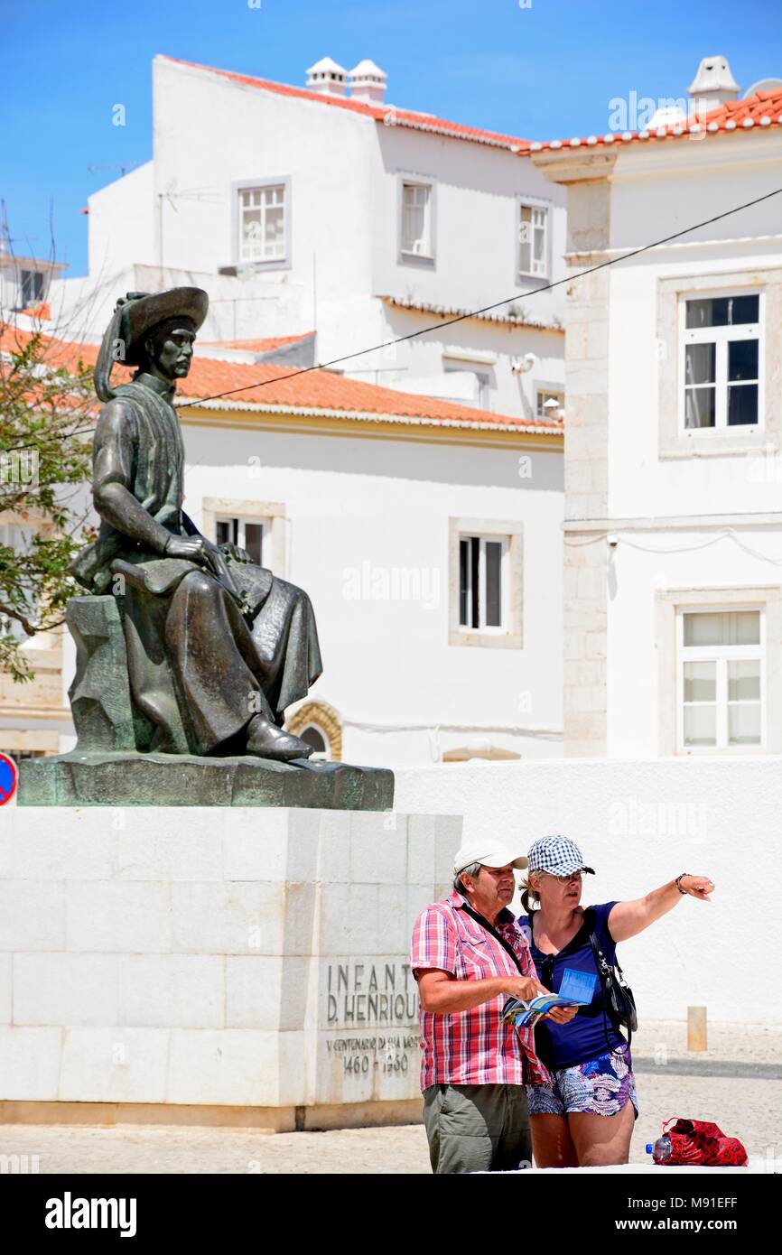 Ein Paar an einer Karte vor der Statue des Infante Dom Henrique (Prince Henry) in der Stadtplatz mit Stadt Gebäude an der Rückseite, Lagos suchen, Alg Stockfoto