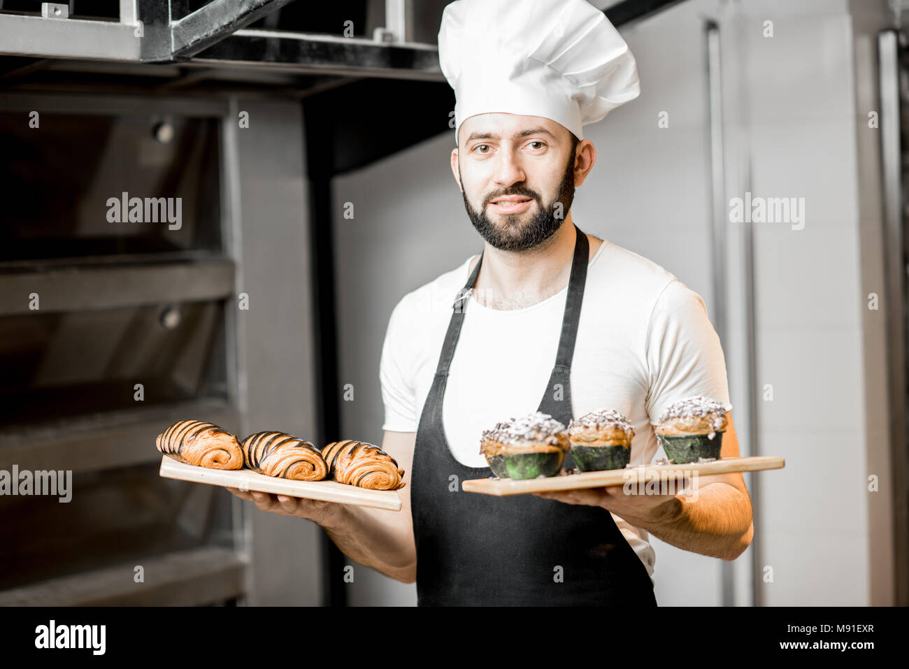 Konditor mit süßem Gebäck in der Fertigung Stockfoto