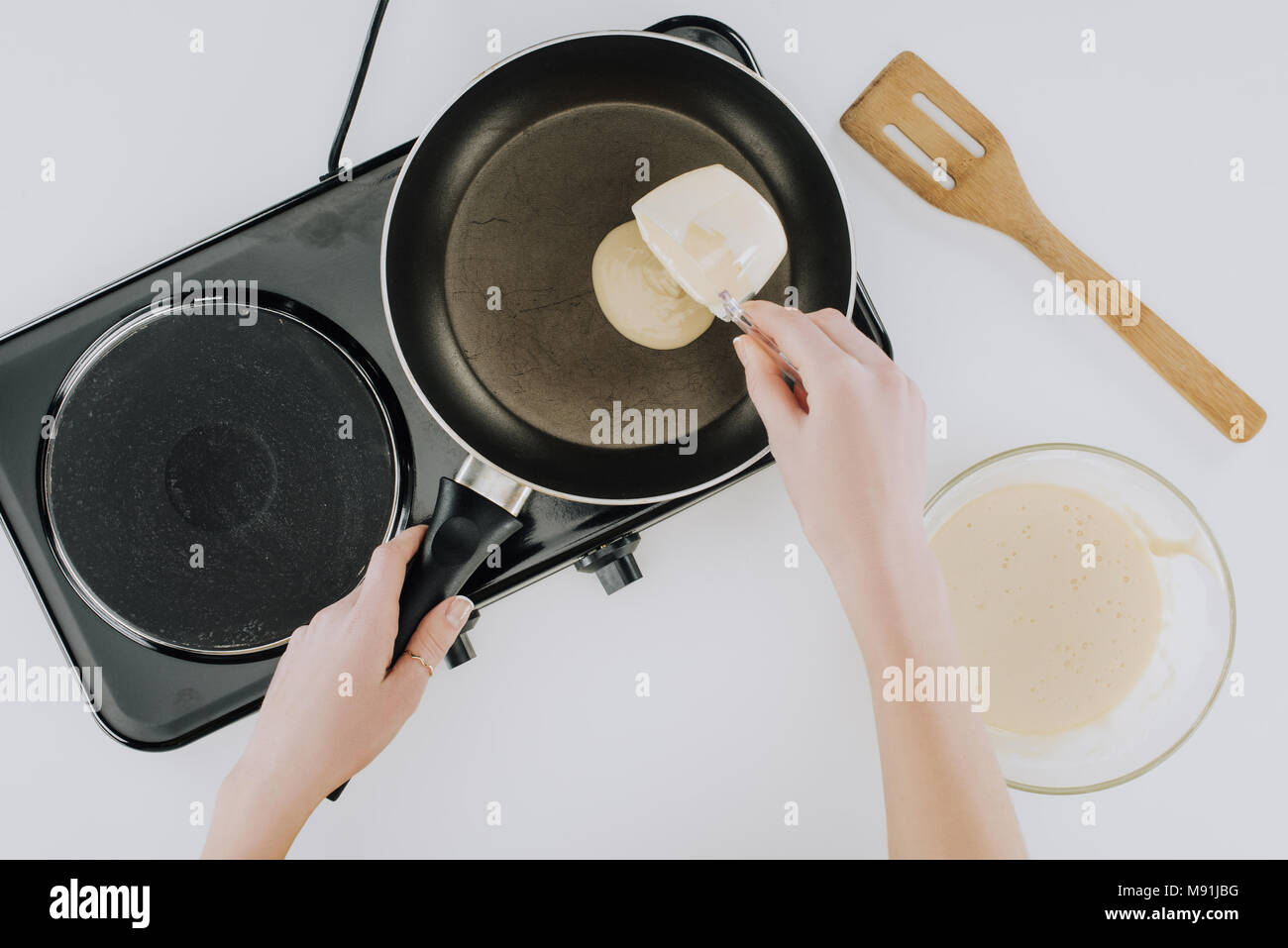 7/8 Schuß von Person kochen Pfannkuchen auf der Pfanne auf Grau Stockfoto