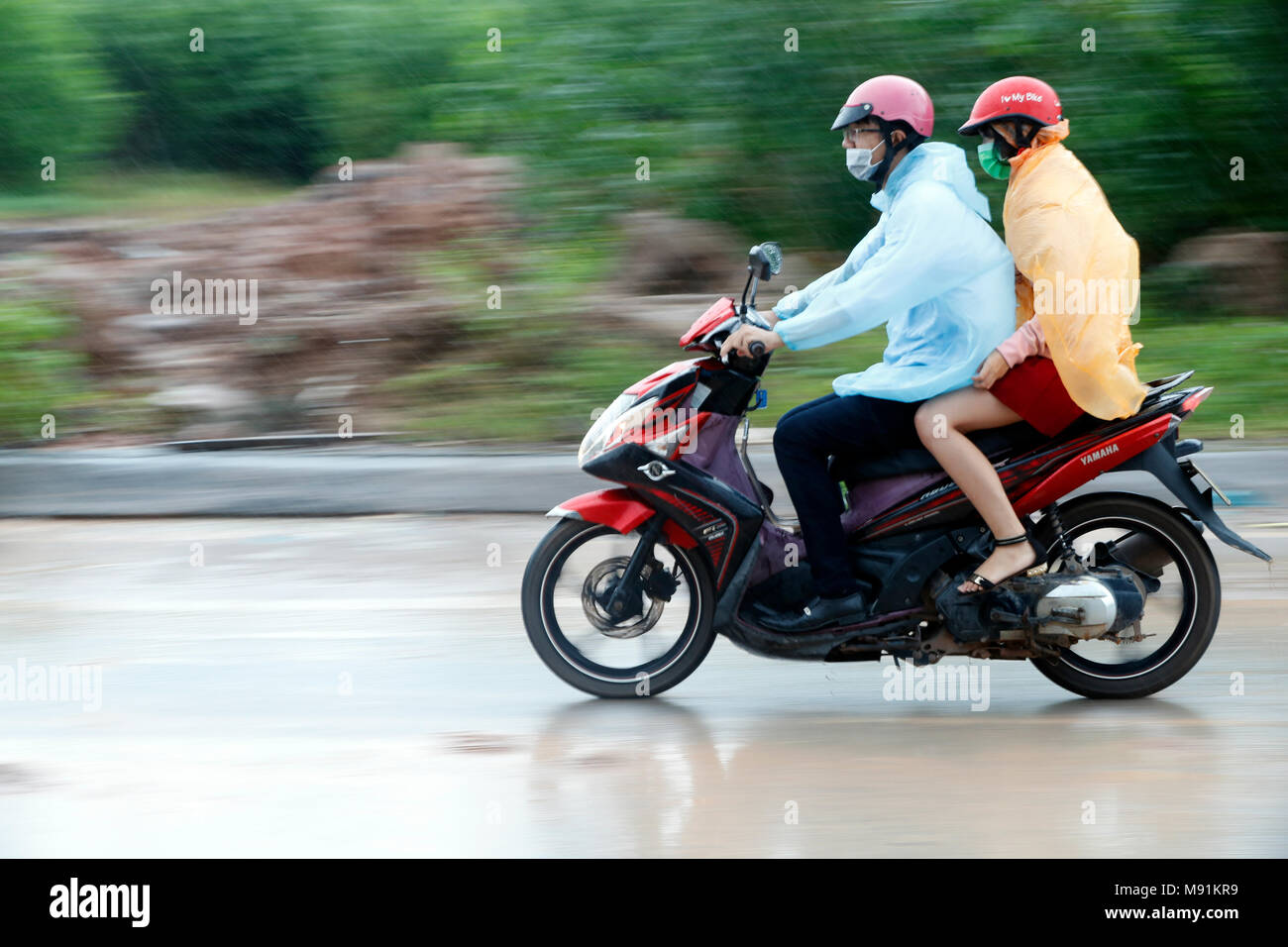 Schwere Monsunregen. Mann und Frau, die ein Motorrad. Phu Quoc. Vietnam. Stockfoto