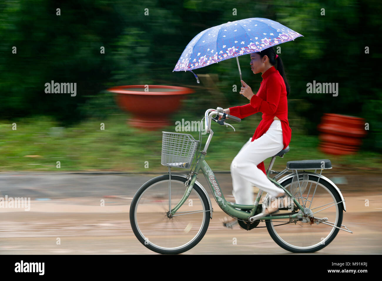 Schwere Monsunregen. Mädchen fahren mit dem Fahrrad. Phu Quoc. Vietnam. Stockfoto