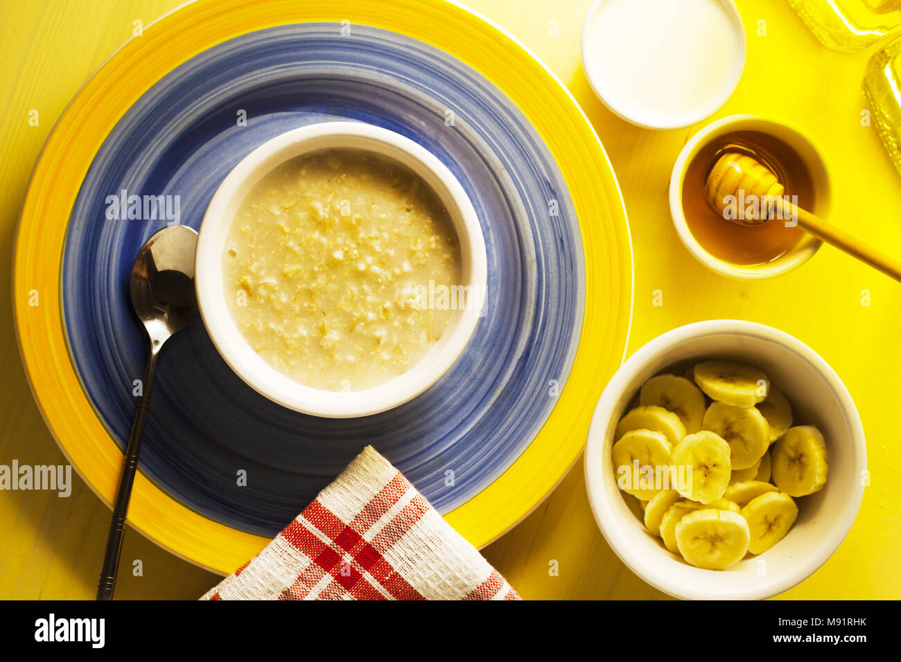 Ein Frühstückstisch von organischen heissen Brei und Banane mit Honig Stockfoto