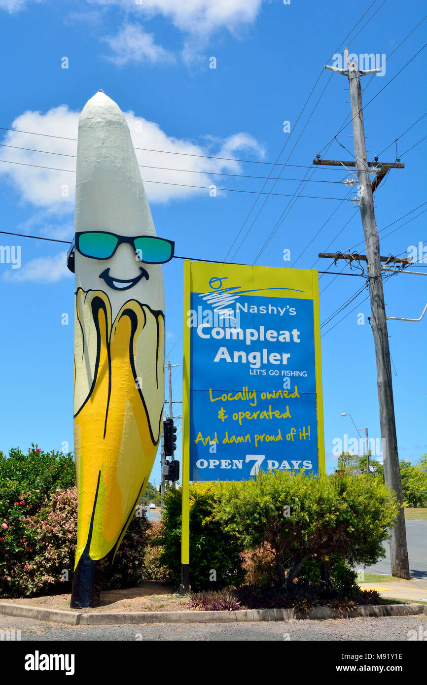 Mackay, Queensland, Australien - 30. Dezember 2017. Big Banana Statue im Norden von Mackay, mit Werbung, Strommast und Vegetation. Stockfoto