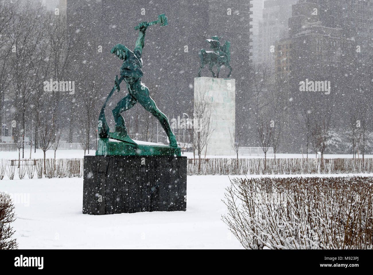 Vereinten Nationen. 21 Mär, 2018. Die 'Lasst uns Beat Schwerter zu Pflugscharen" Skulptur (Vorne) ist im Schnee am Sitz der Vereinten Nationen in New York gesehen, am 21. März 2018. Credit: Li Muzi/Xinhua/Alamy leben Nachrichten Stockfoto