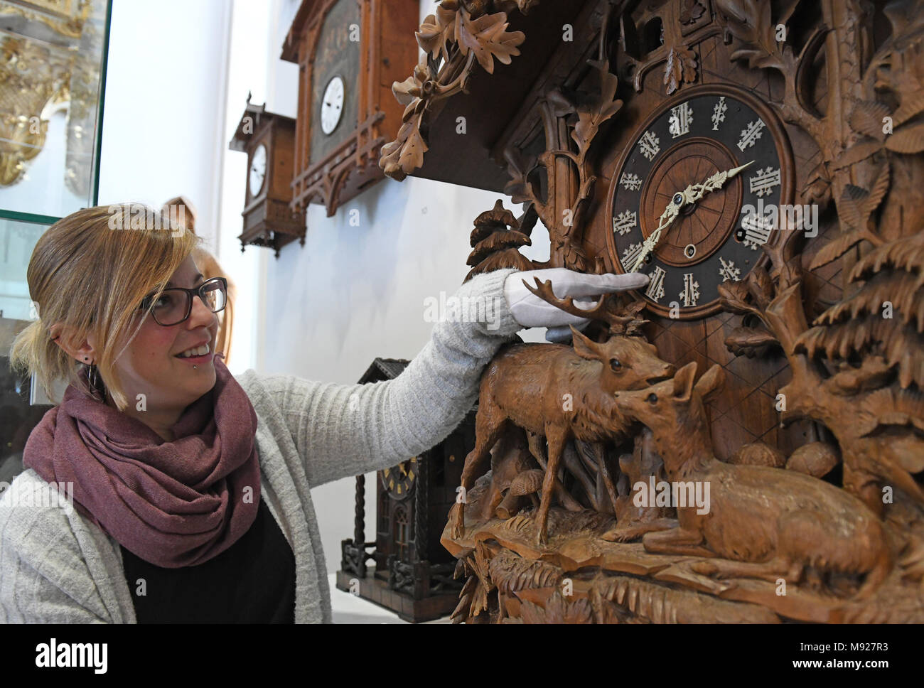 19 März 2018, Deutschland, Furtwangen: Trainee Isabelle Zink Änderungen  eine Historische Kuckucksuhr Sommer Zeit im Deutschen Uhrenmuseum. Die  Mitteleuropäische Zeit (MEZ) wird 125 Jahre in Deutschland. Am 1. April  1893 wurde es