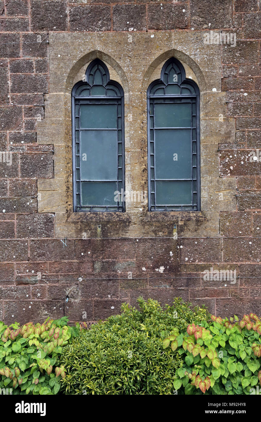 Ein paar Bleiglasfenster an Knightshayes Court, Tiverton, Devon, Großbritannien. Das Gebäude und die Gärten des National Trust. Stockfoto