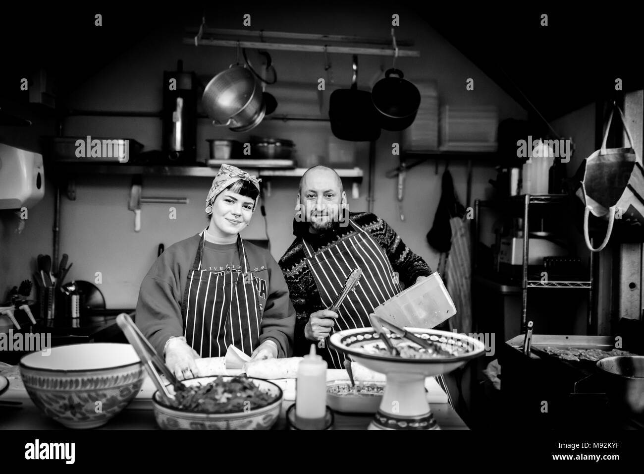 The Shambles, York 16. Februar 2018. Frau in einem Kopftuch und männlich Mann Koch in einer Schürze auf ein warmes Essen, Stall oder in der Küche für die Kamera posieren Stockfoto