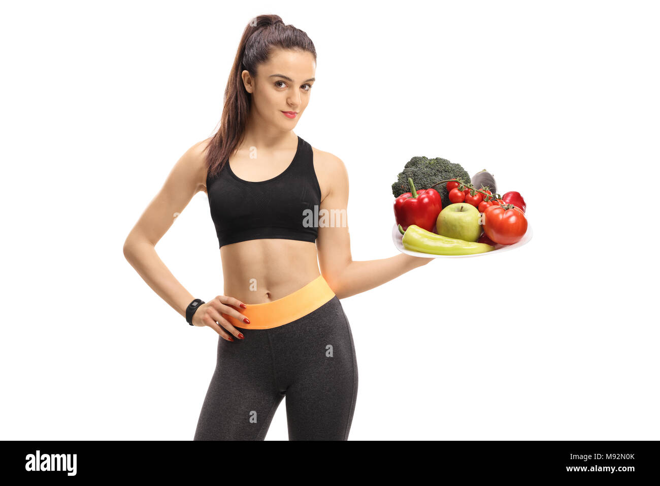 Fitness Mädchen, dass eine Platte von Gemüse und Obst auf weißem Hintergrund Stockfoto