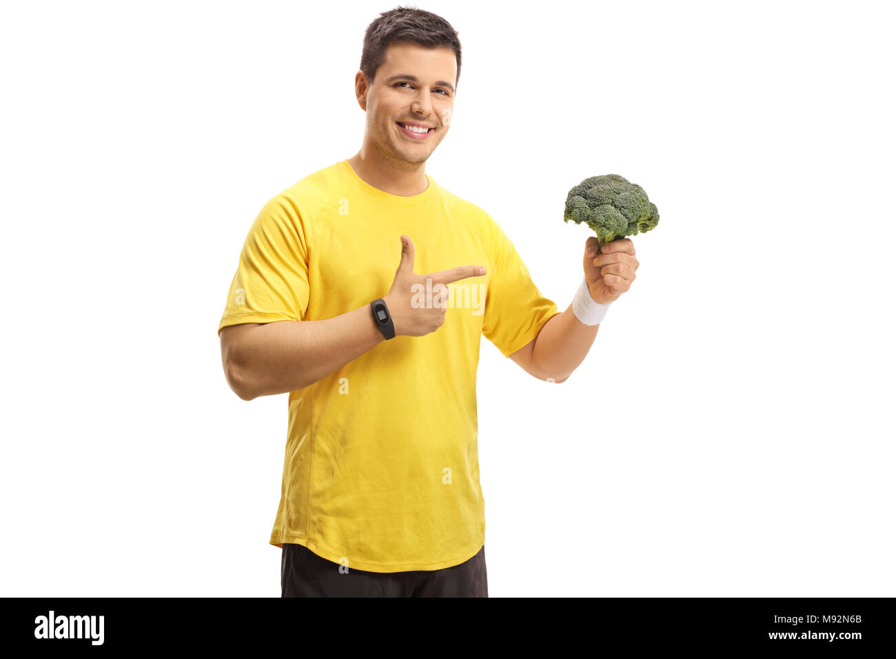 Junger Mann mit Brokkoli und zeigt auf weißem Hintergrund Stockfoto