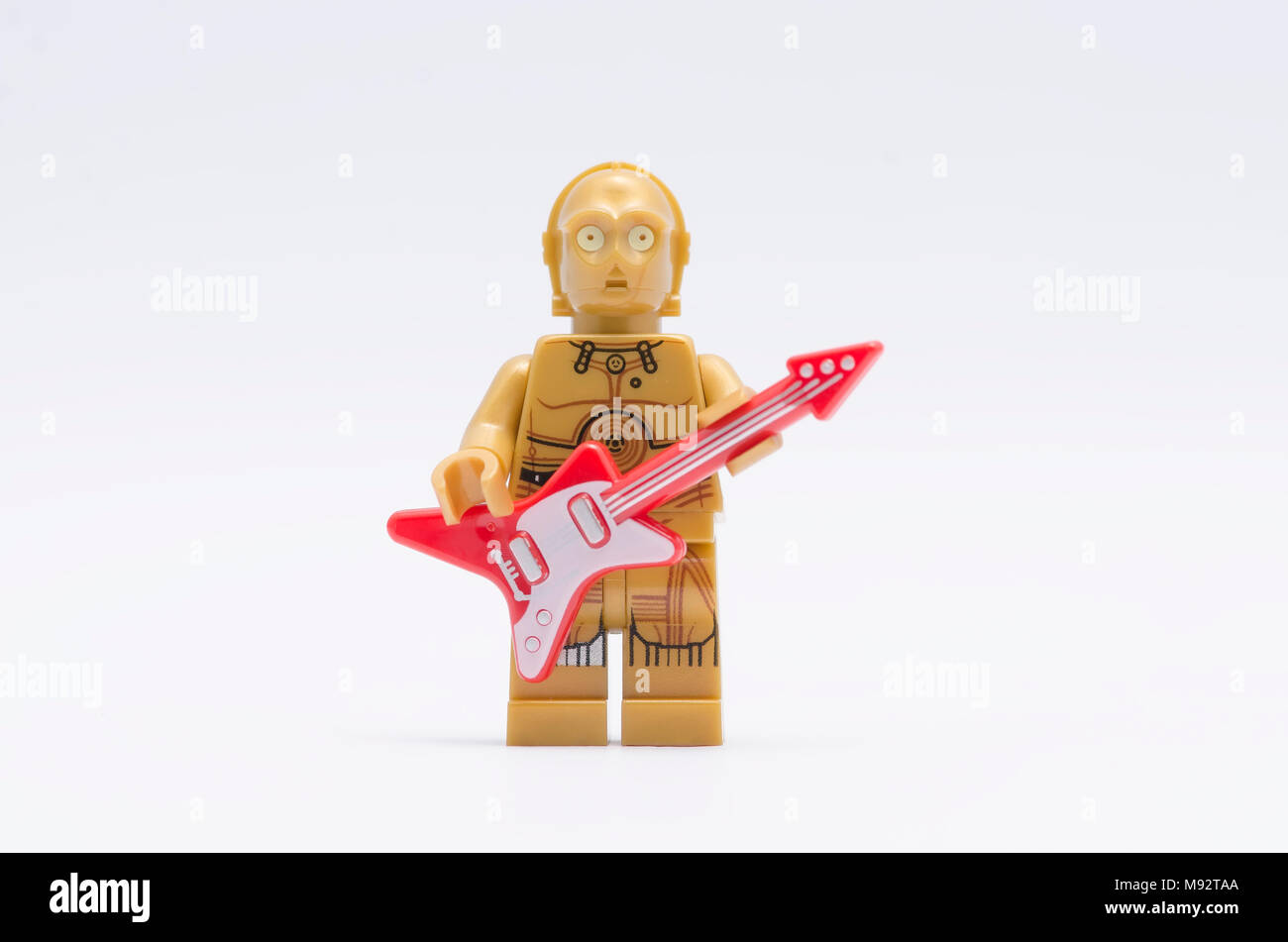 Lego c3po Minifigur Holding eine Gitarre auf weißem Hintergrund. Stockfoto
