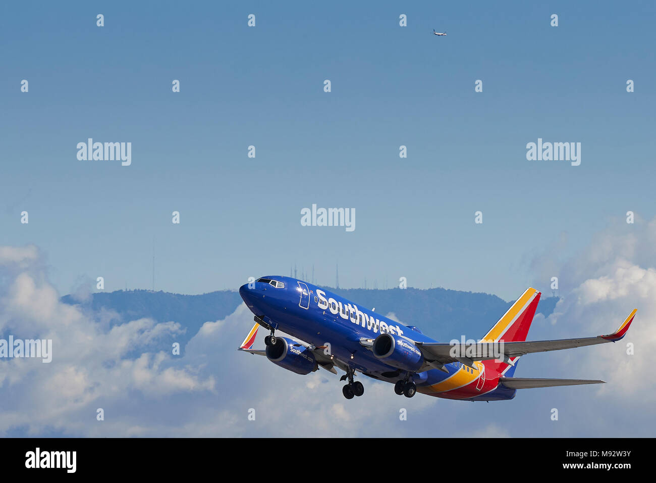 Southwest Airlines Boeing 737 Airliner vom Internationalen Flughafen Los Angeles, LAX, Wolken und Schnee bedeckten San Gabriel Berge dahinter. Stockfoto