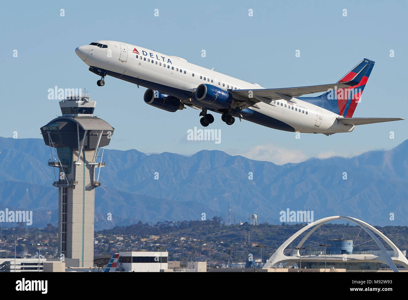 Delta Air Lines Boeing 737-800 Passenger Jet aus Los Angeles International Airport LAX. Control Tower und San Gabriel Berge dahinter. Stockfoto