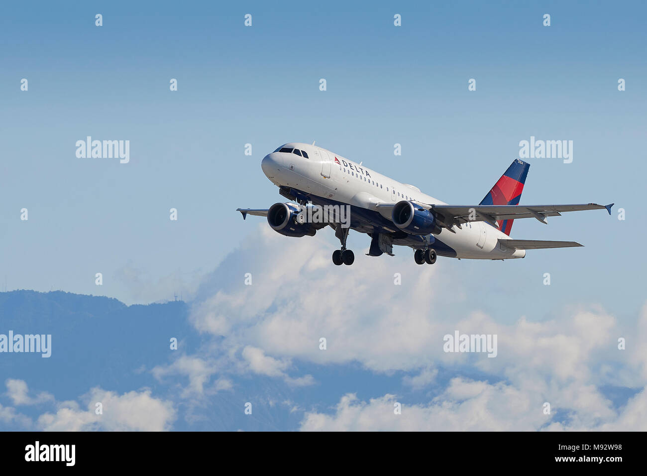 Delta Air Lines Airbus A319 Airliner vom Internationalen Flughafen Los Angeles, LAX, Wolken bedecken die San Gabriel Berge dahinter. Stockfoto