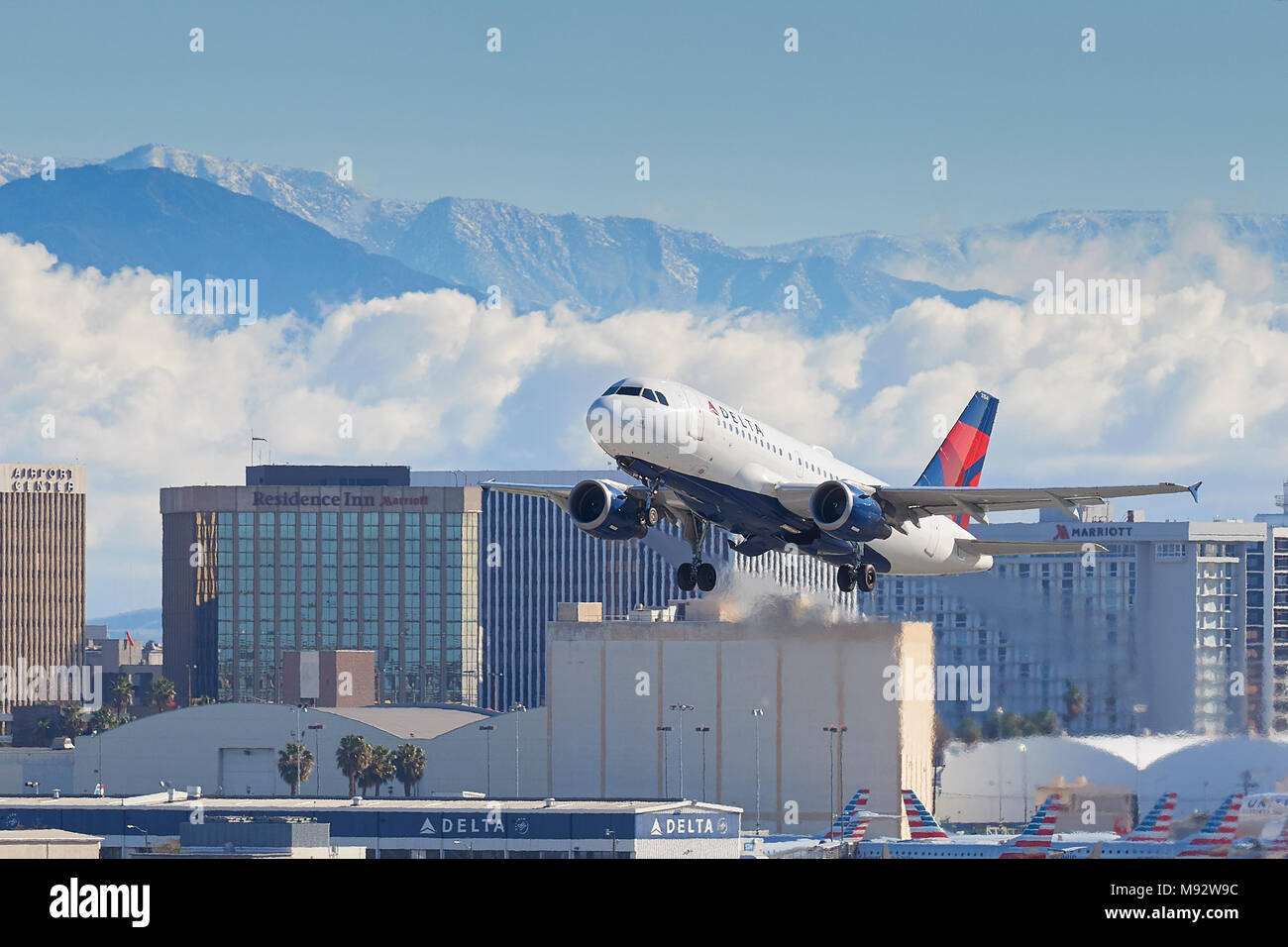 Delta Air Lines Airbus A319 Airliner vom Internationalen Flughafen Los Angeles, LAX, Wolken und die schneebedeckten San Gabriel Berge dahinter. Stockfoto