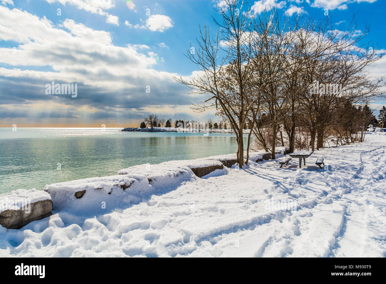 Winterlandschaft Szene mit weißen Schnee und eisigen Wasser See Küste, an einem schönen sonnigen Tag mit hohem Kontrast Himmel Stockfoto