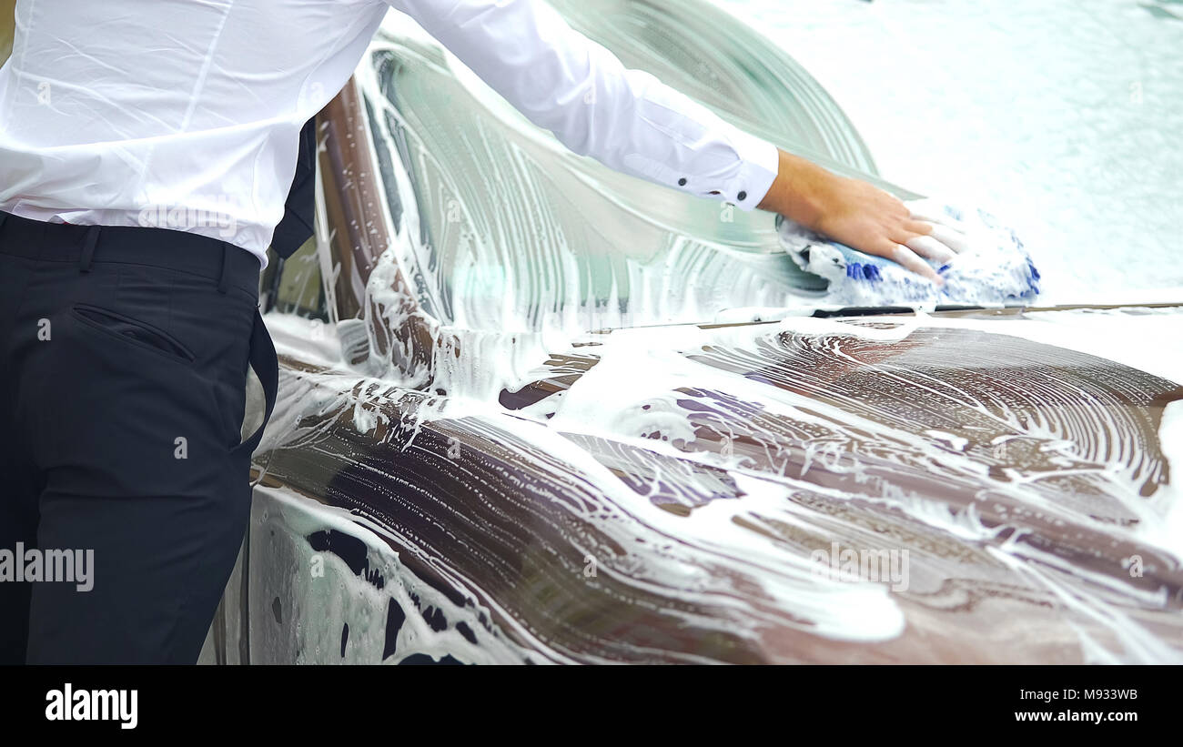 Gewissenhafte Fahrer gründlich zu waschen Windschutzscheibe von seiner luxuriösen Auto, Waschanlage Stockfoto