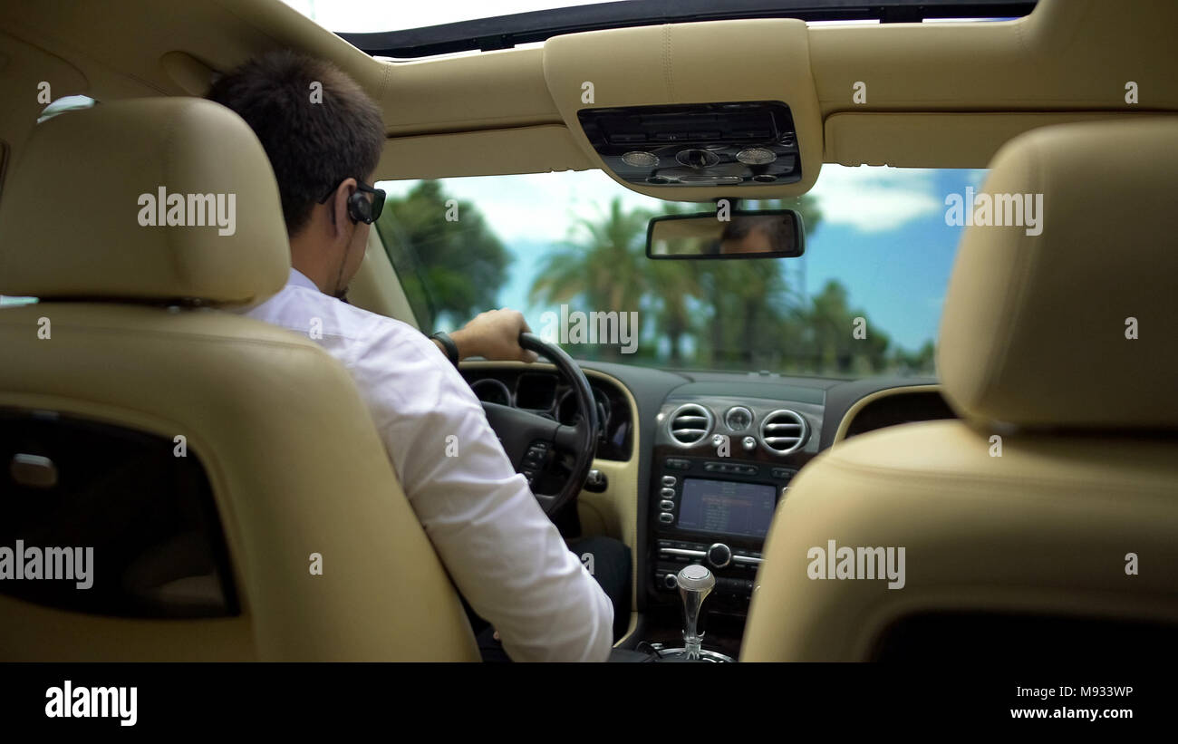 Geschäftsmann Autofahren und am Telefon sprechen über Wireless Headset, Technologie Stockfoto