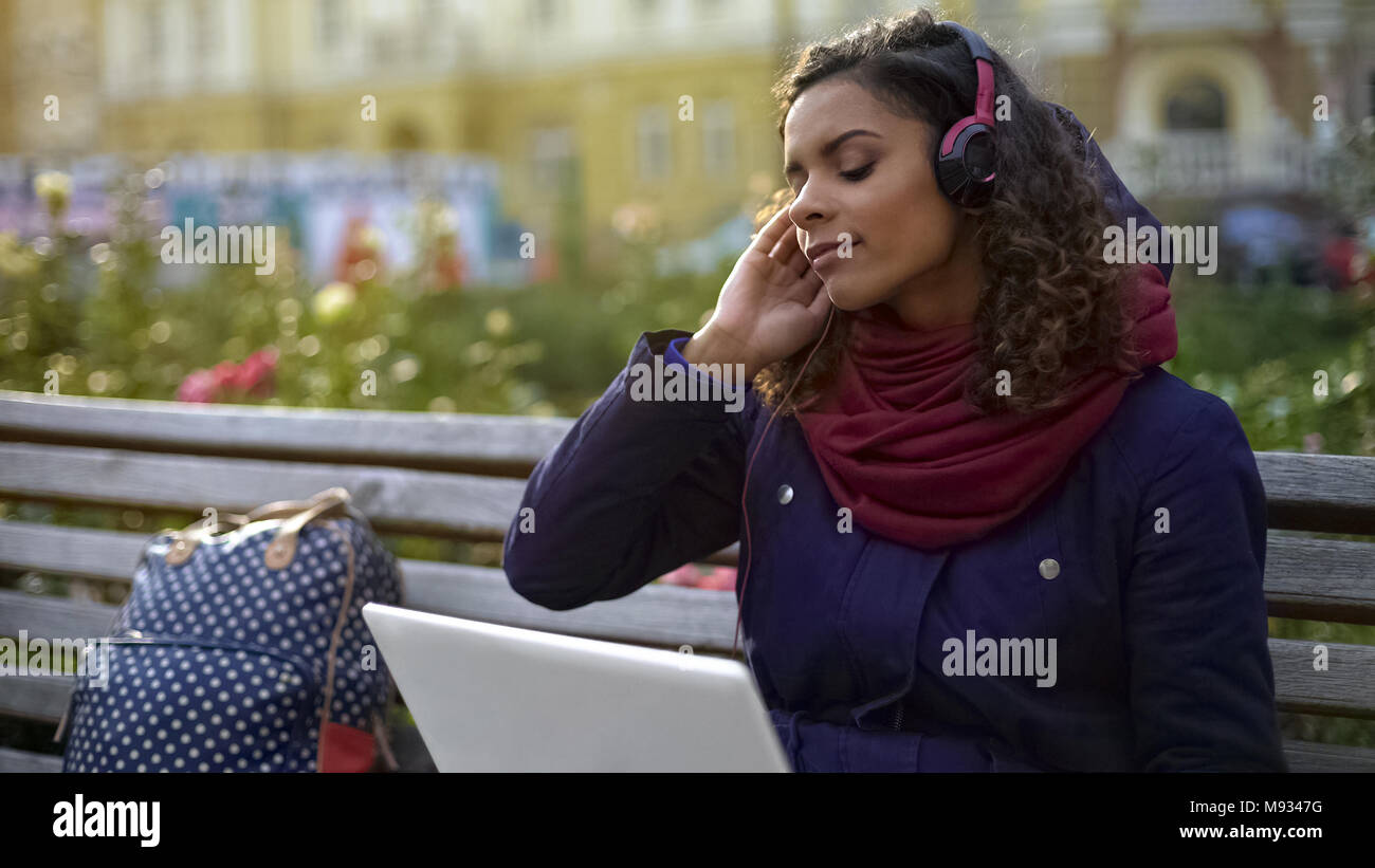 Hübsches Mädchen in Kopfhörer genießen Sie Atmosphäre der Lieblingsband Konzert im Freien Stockfoto
