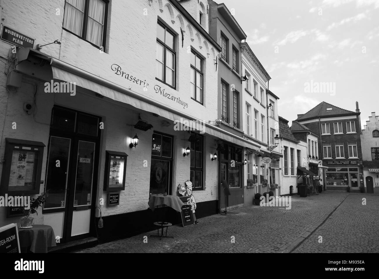 Huidenvettersplein, Brügge, Belgien: Die Brasserie 't Mozarthuys und andere Restaurants auf dem zauberhaften kleinen Platz. Schwarz-weiße Version Stockfoto
