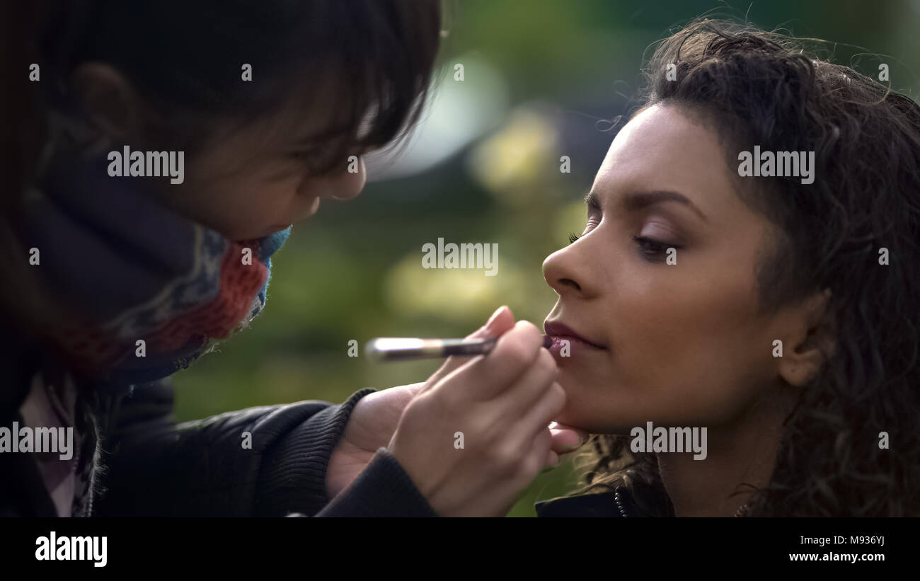 Make-up Artist Anwendung Lippenstift auf Modellen, die Lippen, die Schönheit der Natur von Biracial Dame Stockfoto