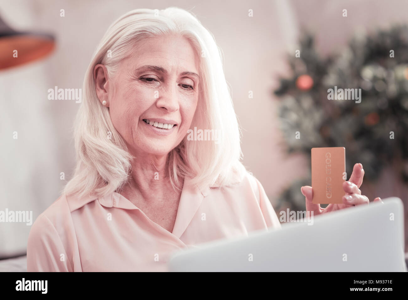 Zufriedene Frau am Bildschirm holding Kreditkarte suchen interessieren. Stockfoto