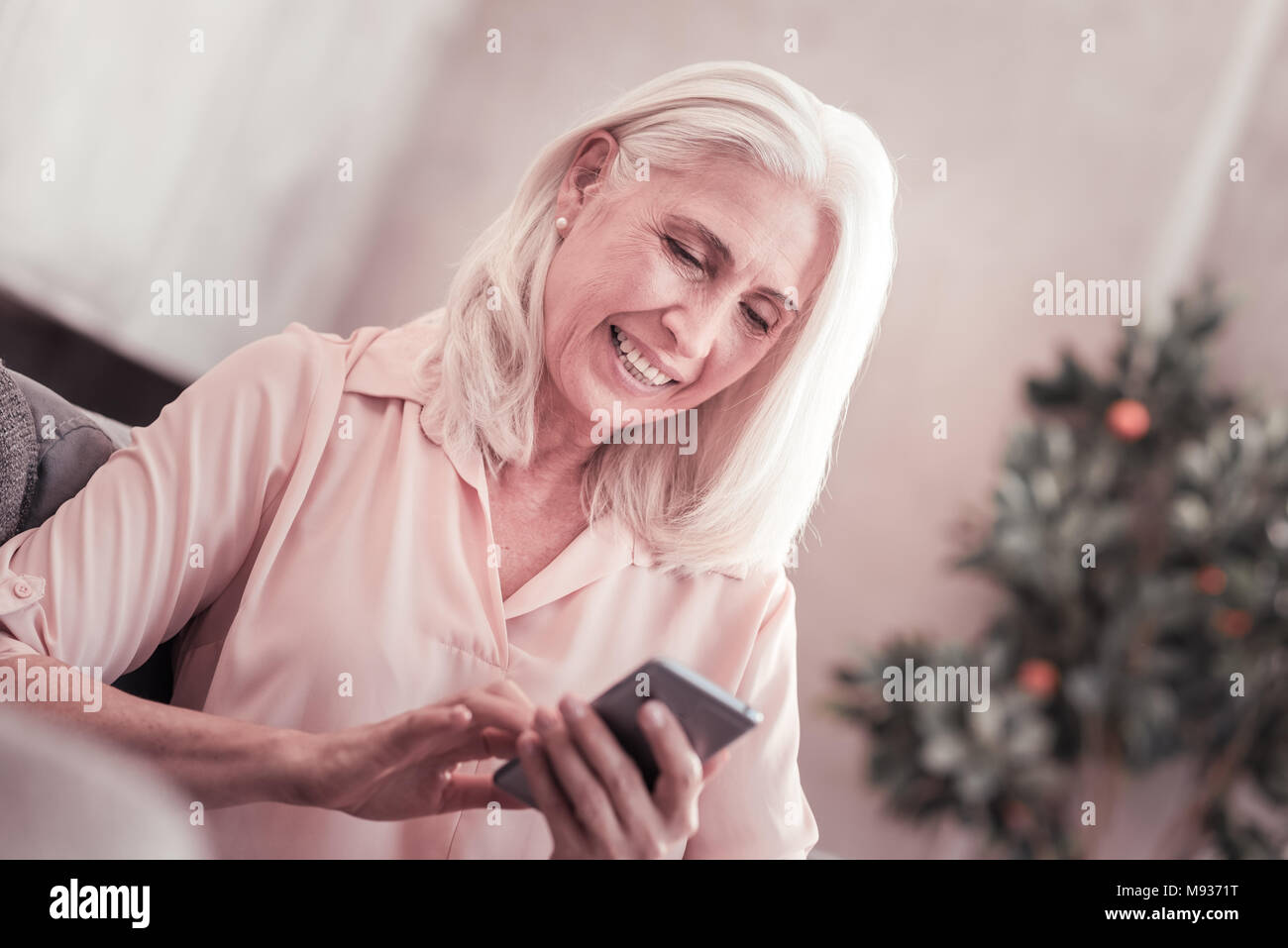 Im Alter von niedlichen Dame Messaging und lächelnd. Stockfoto