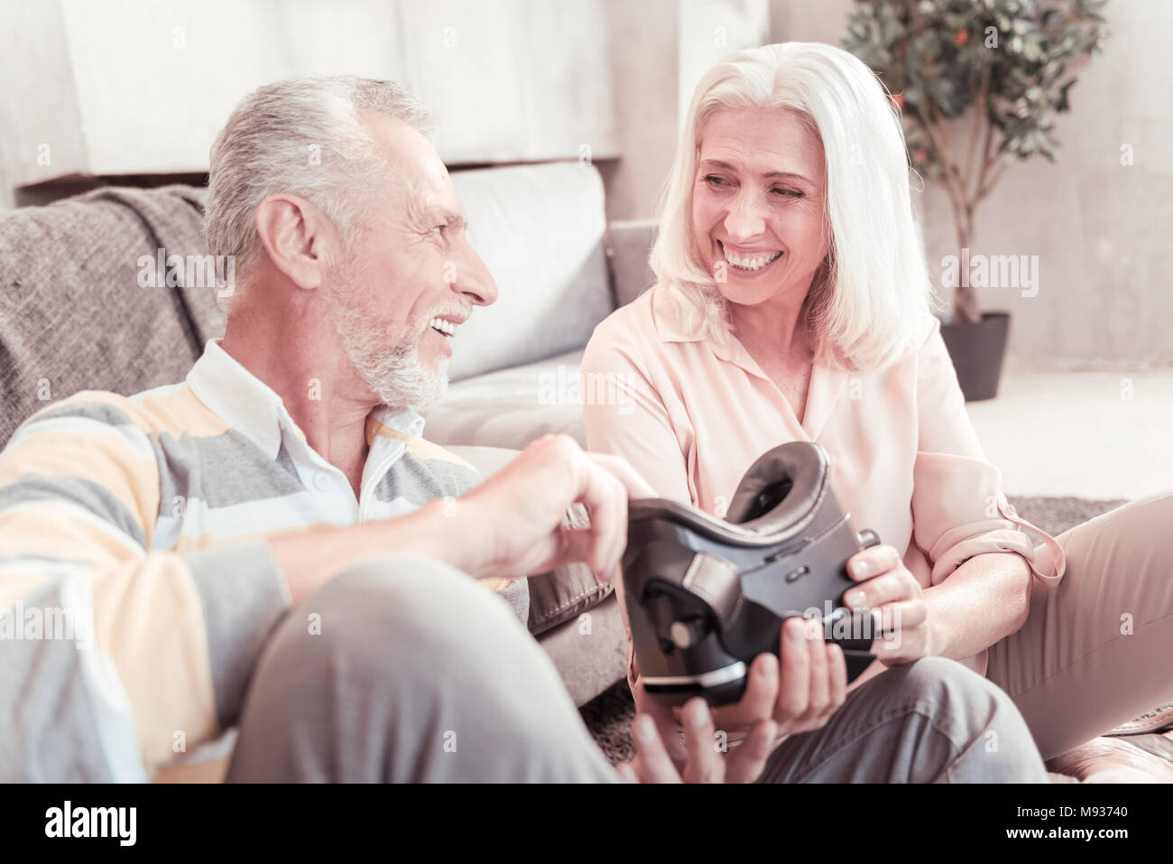 Freudige besetzten Paar hält VR-Brille und kommuniziert. Stockfoto