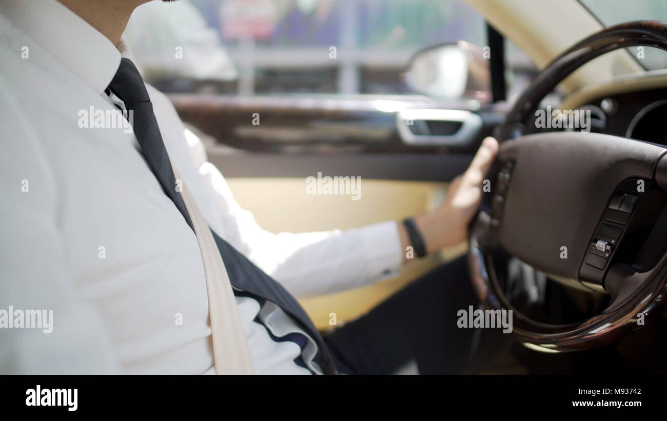 Persönlichen Chauffeur in Anzug fahren Luxusauto, teure Dienstleistungen Stockfoto