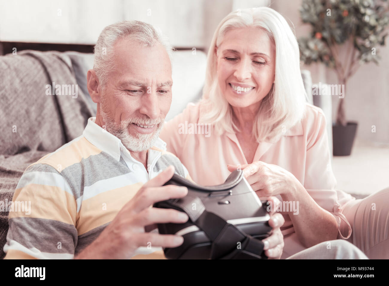 Interessierte im Alter von Paar mit Blick auf VR-Brille auf. Stockfoto