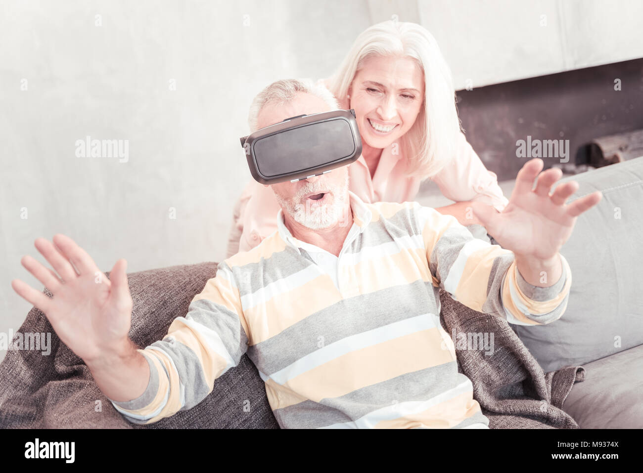 Unerschüttert Mann mit VR-Brille und auf dem Sofa sitzen erstaunt. Stockfoto